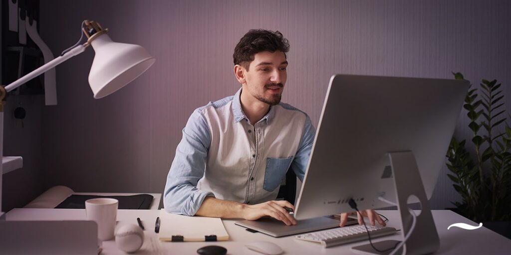 homem ao computador em escritório trabalhando em marketing de conteúdo