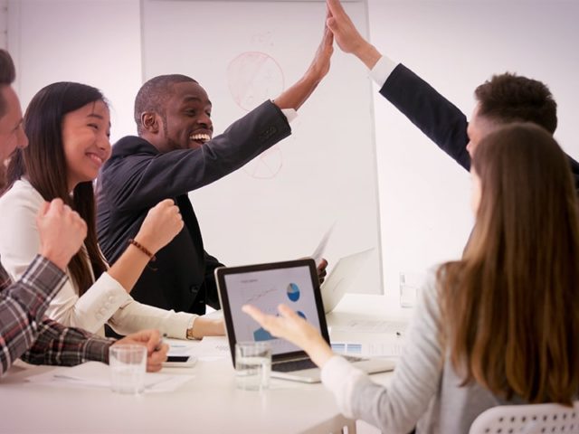 equipe de marketing e vendas celebrando no escritório